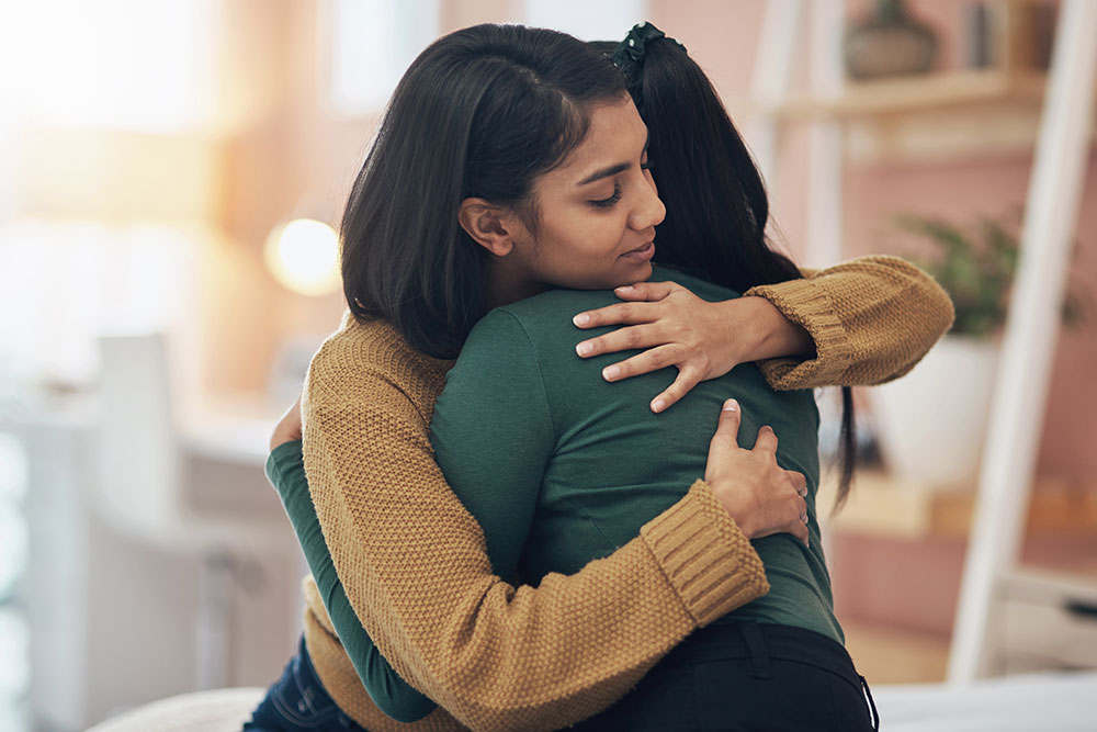 Female living kidney donor hugs her loved one.