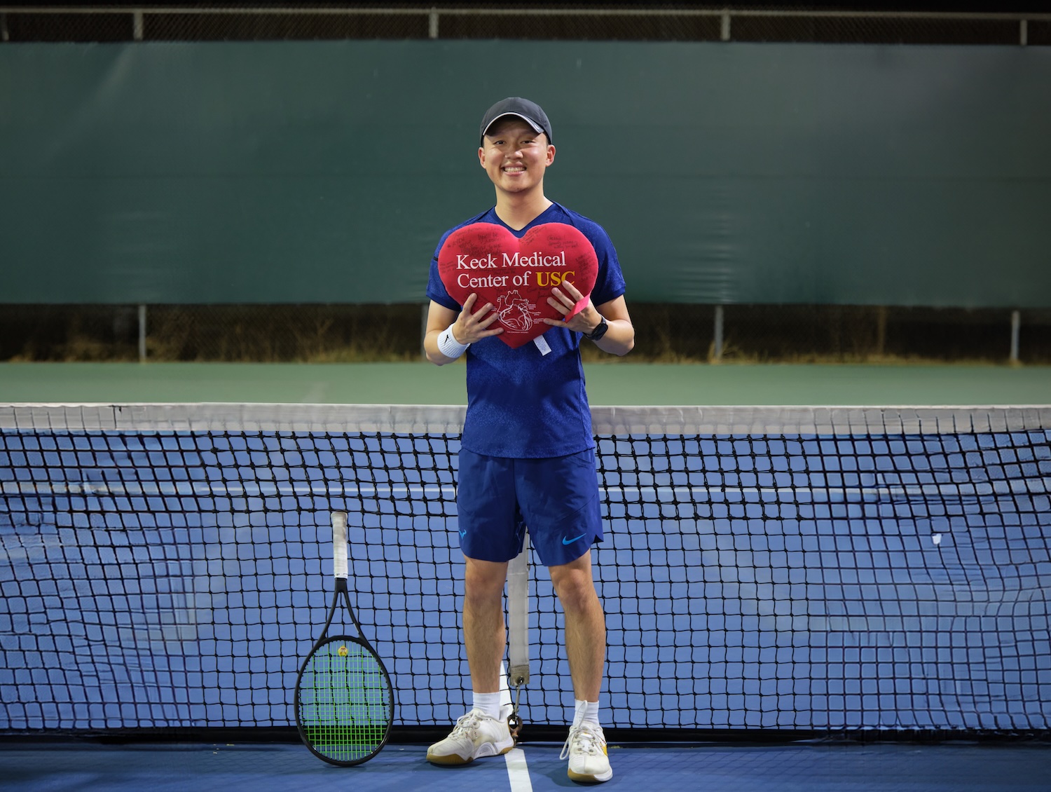 Keck Medicine of USC patient Wen Ning standing on a tennis court.