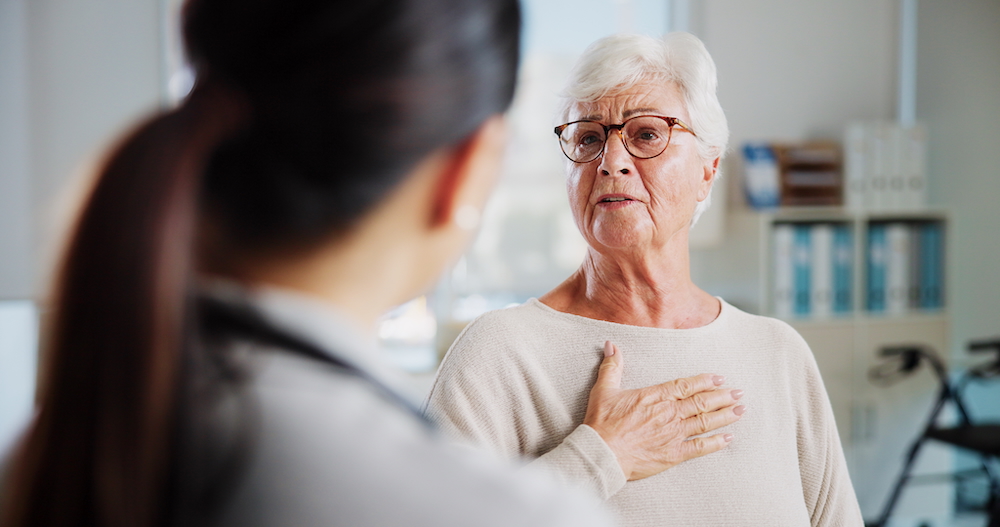 Senior female patient talks to female doctor about possible a heart arrhythmia.