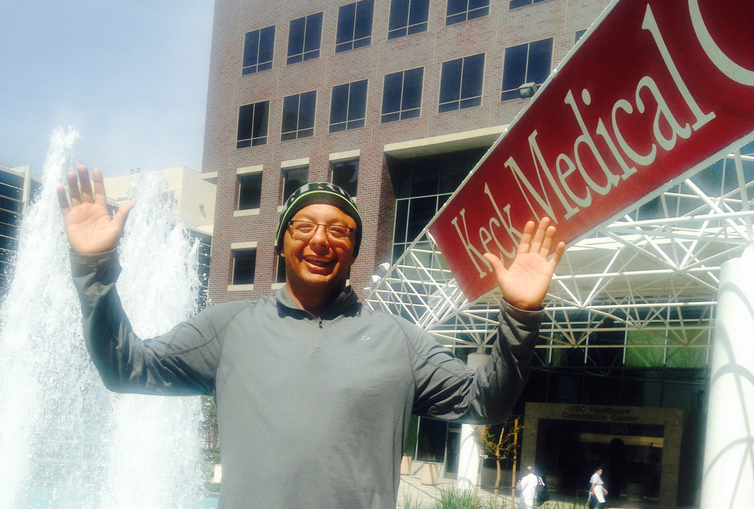 USC Brain Tumor Center patient Gabe Rios stands in front of Keck Medical Center.